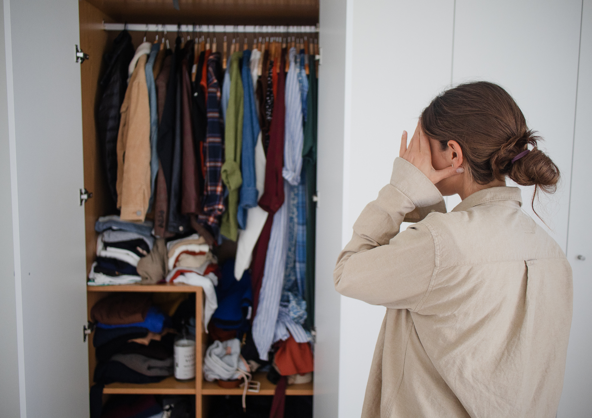 Woman overwhelmed by a cluttered closet